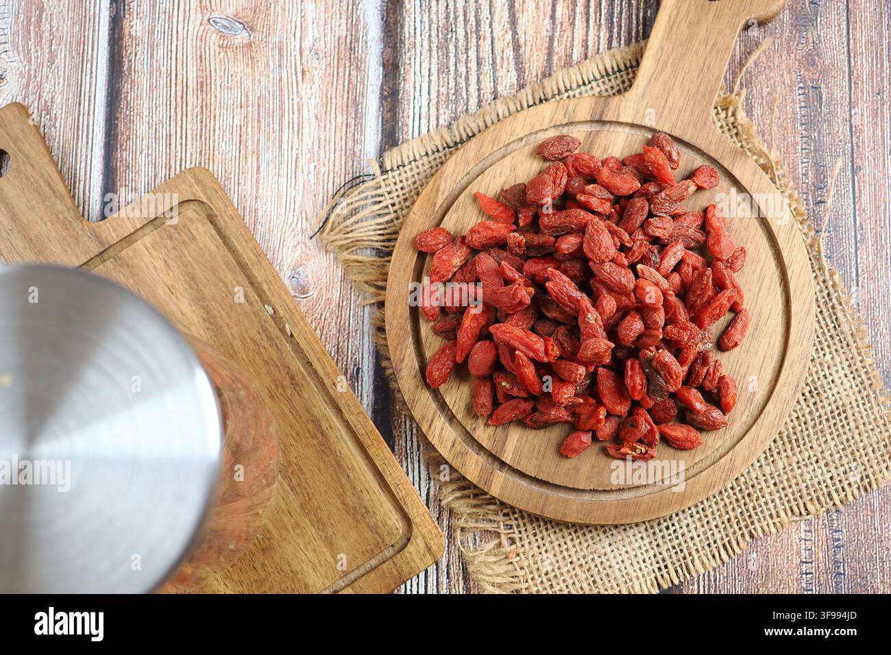 Bacche di goji essiccate su un vassoio di legno in una cucina Foto Stock