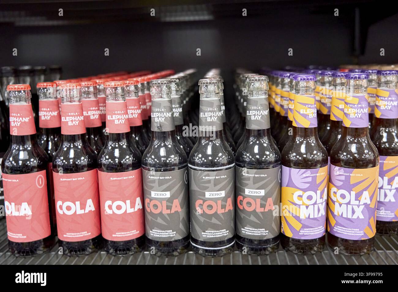 File di bottiglie di cola colorate e miscela di cola del marchio Elephant Bay su uno scaffale nel supermercato, comprare bevande nel mercato delle bevande, Germania, Eleph Foto Stock