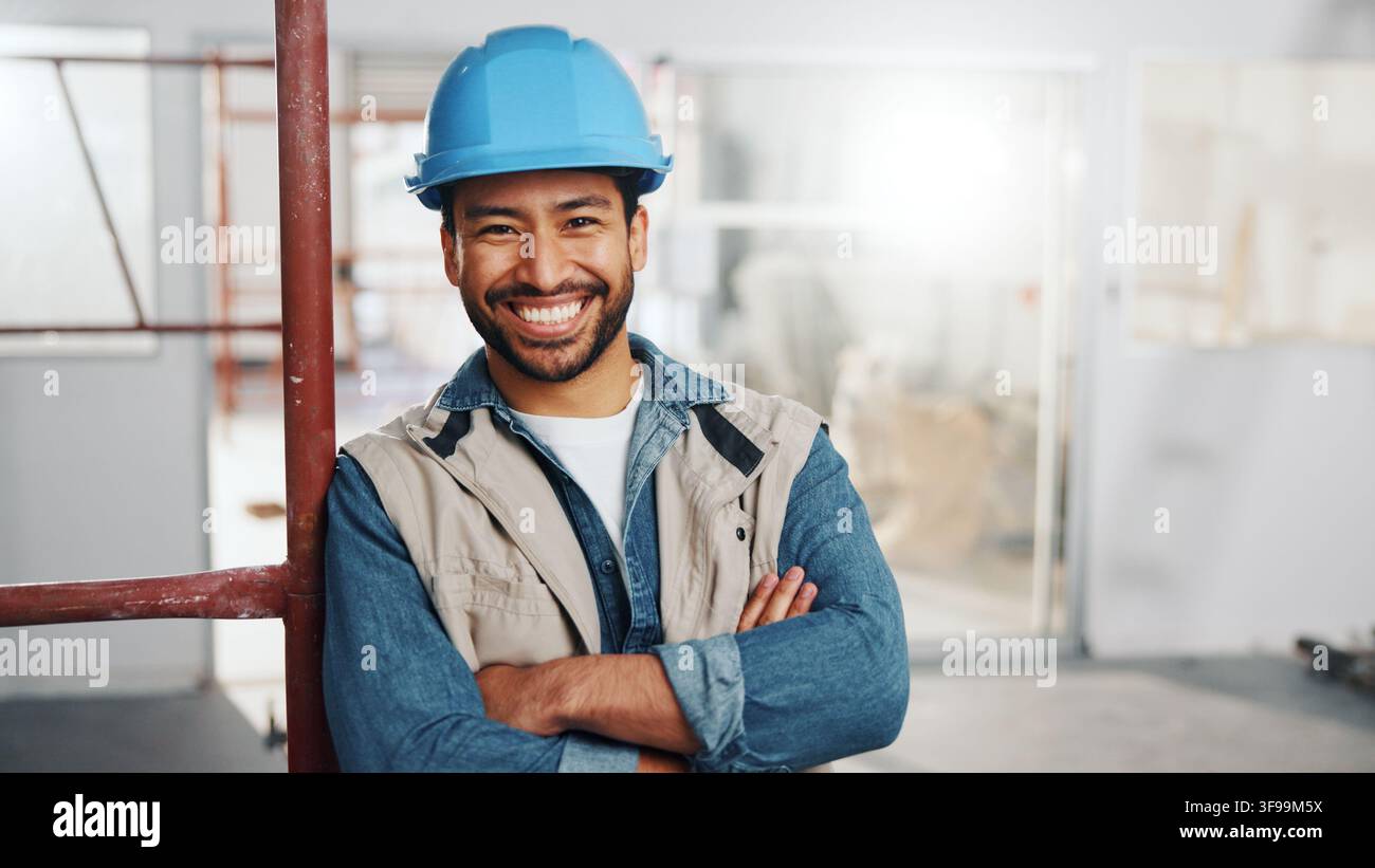Lavoratore, uomo e felice con le braccia incrociate per costruzione, progetto di ristrutturazione o lavoro qualificato. Impalcatura, artigiano o sorriso con DPI sul sito per Foto Stock