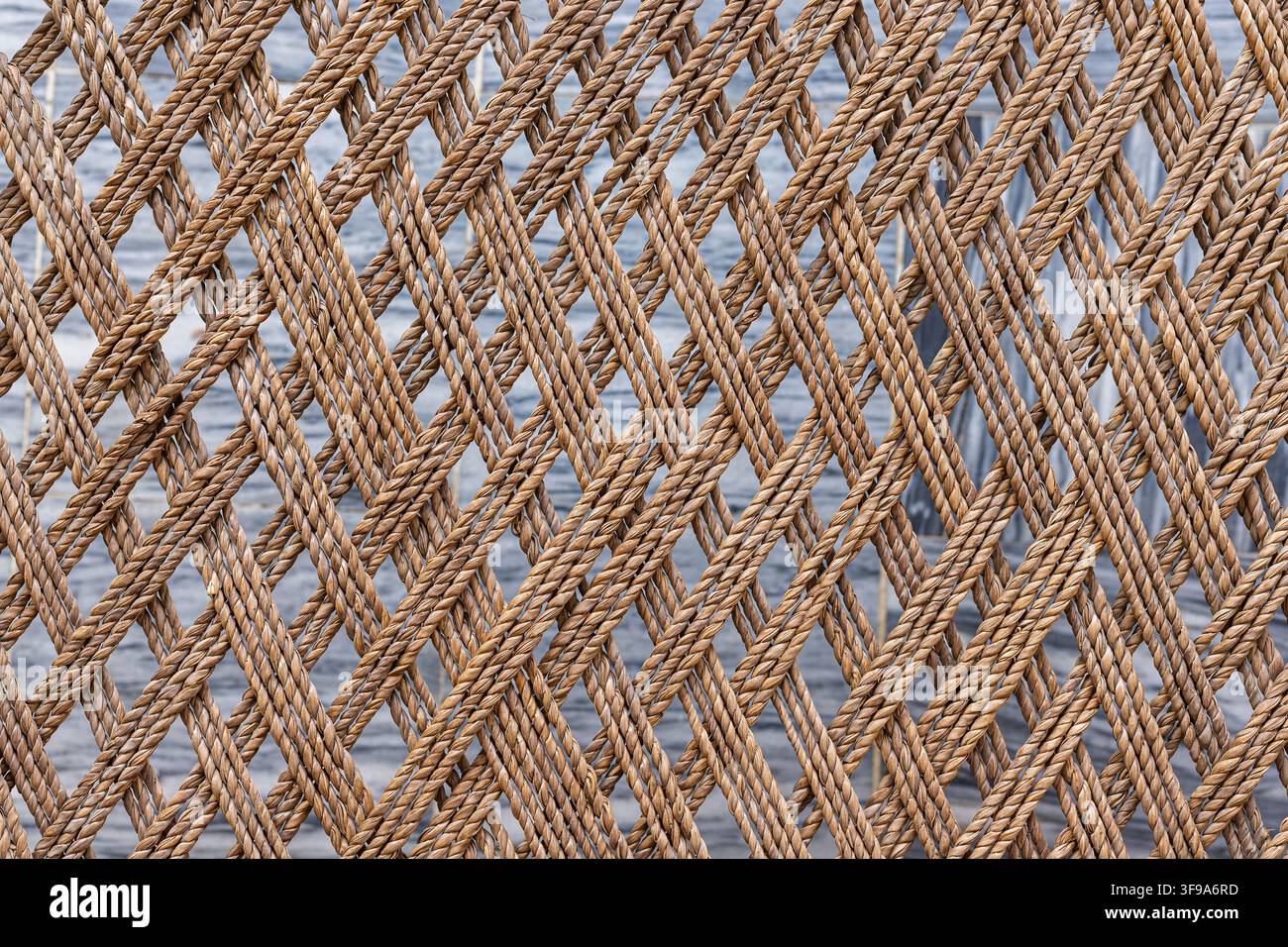 Rete in corda tessuta marrone, primo piano con motivo geometrico a maglia ripetitivo Foto Stock