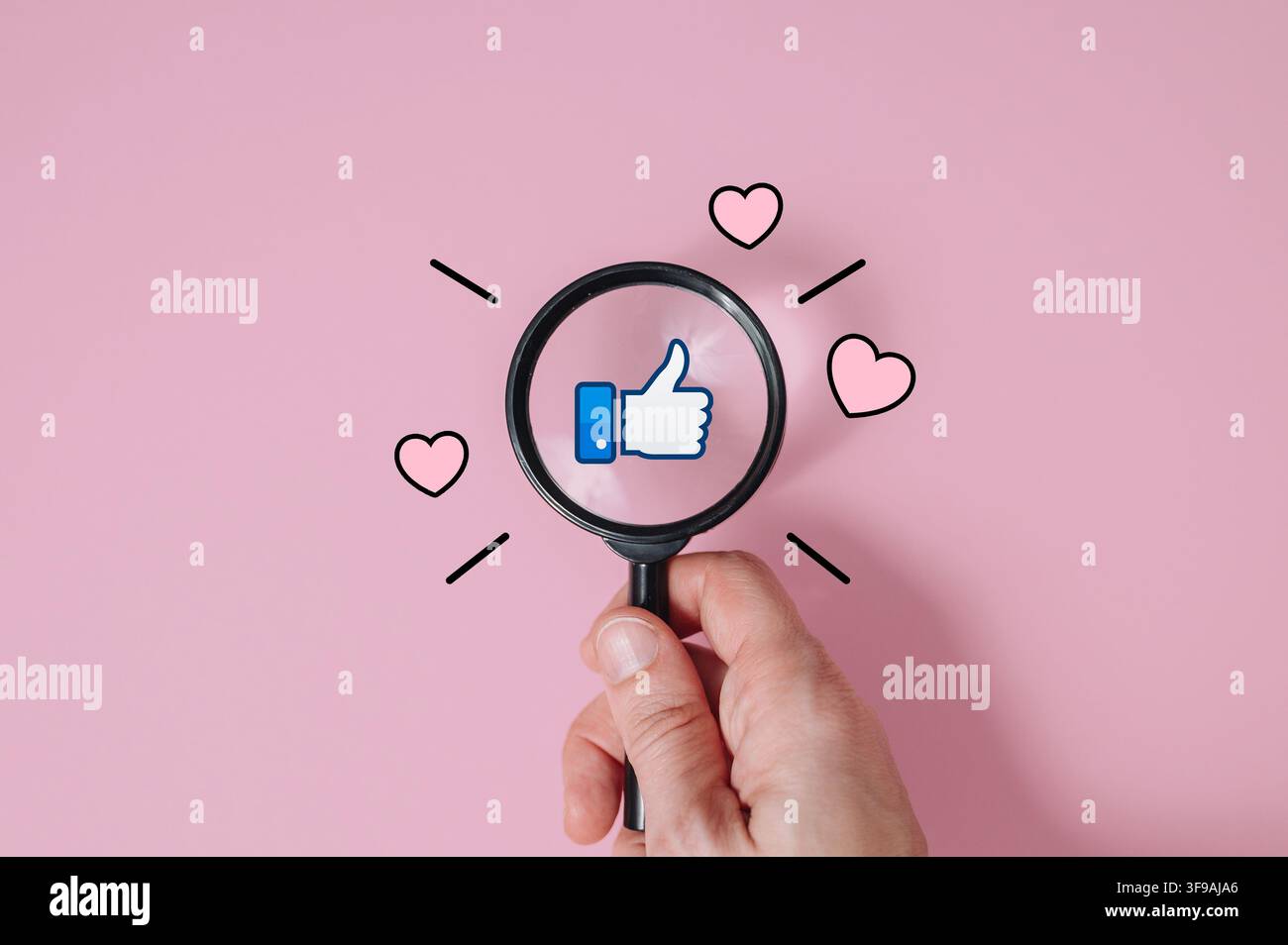 Mano che tiene una lente d'ingrandimento sopra un'icona a forma di pollice alzato su sfondo rosa, soddisfazione del cliente e valutazione del feedback sulla qualità. Foto di alta qualità Foto Stock