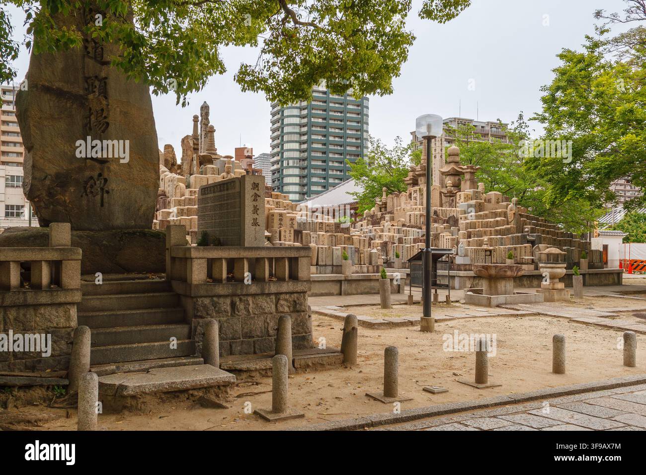 Tombe di pietra tradizionali giapponesi e monumenti commemorativi disposti a più livelli nel complesso storico del tempio Shitennoji a Osaka, Giappone. Foto Stock