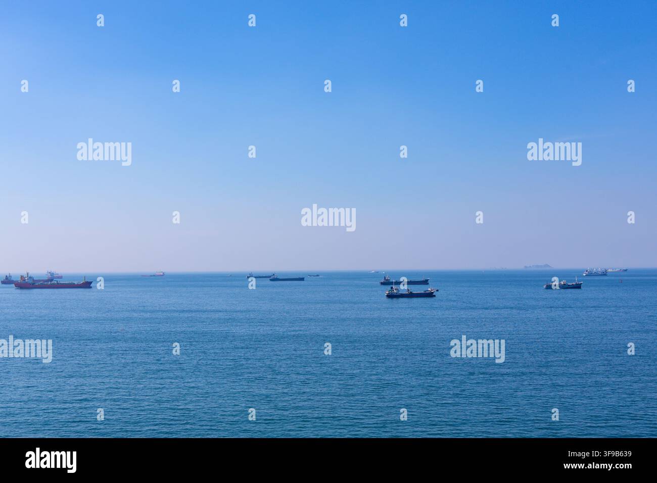 Busan, Corea del Sud - 2 agosto 2026: Diverse navi da carico e mercantili sono ancorate al largo nelle acque costiere blu vicino a Yeongdo-gu in una nebbiosa su Foto Stock