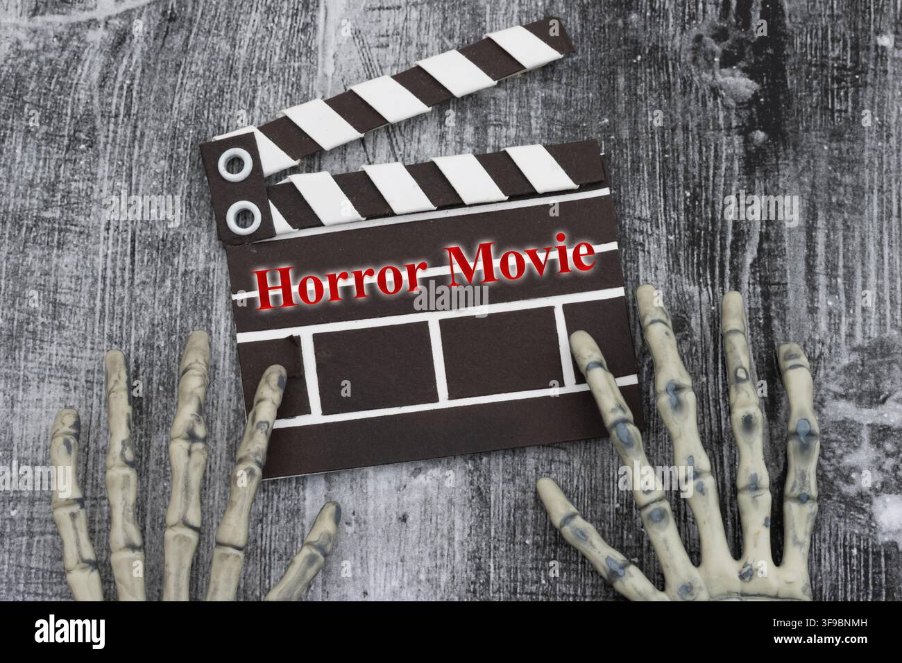 Testo di film horror con mani scheletriche e claquette cinematografica su legno stagionato per festival cinematografici Foto Stock