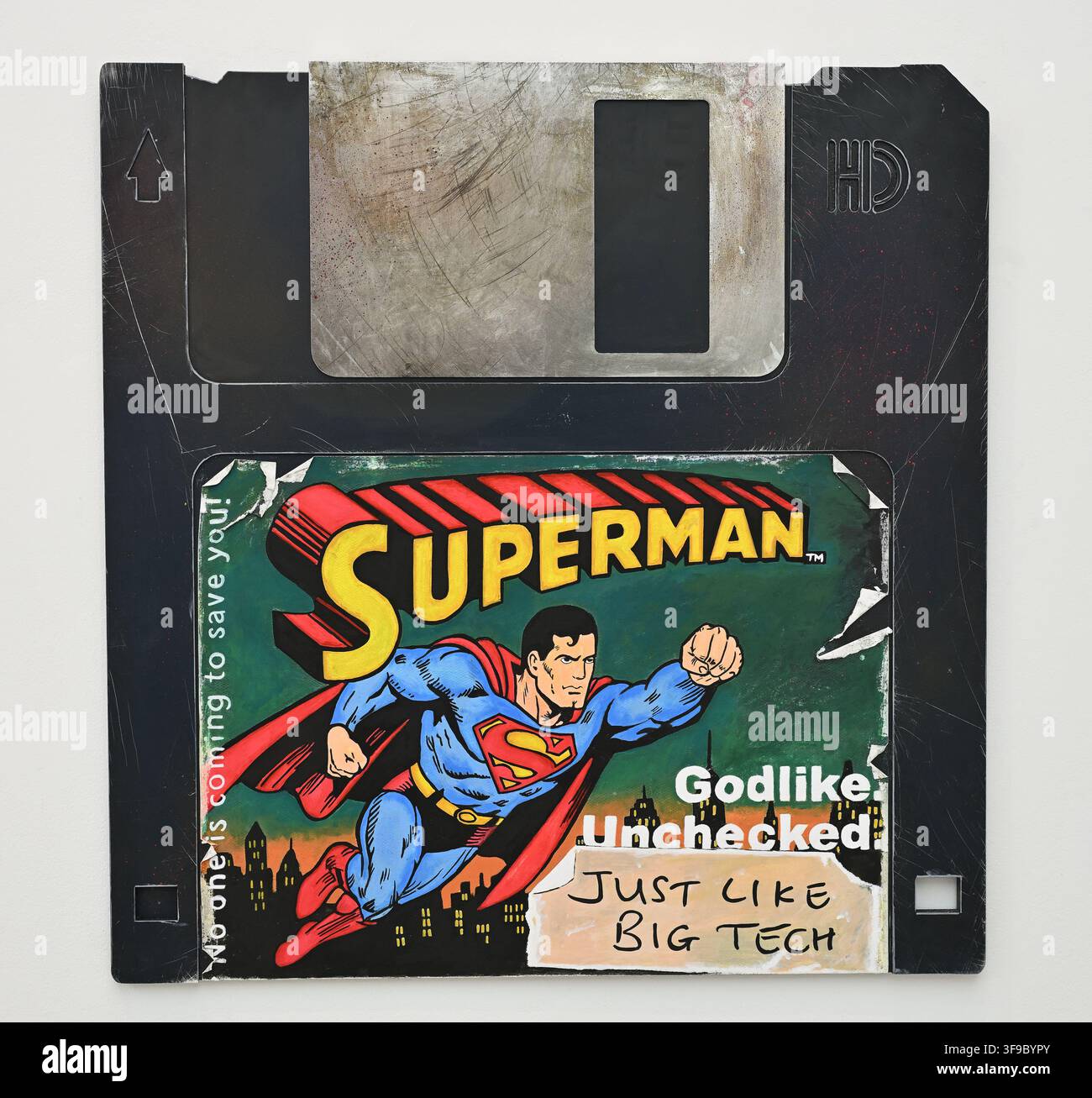 Superman Big Tech - 2026 - Arlo Sinclair - Un floppy disk vintage mostra un'illustrazione di Superman con il testo 'Godlike Unchecked' Foto Stock