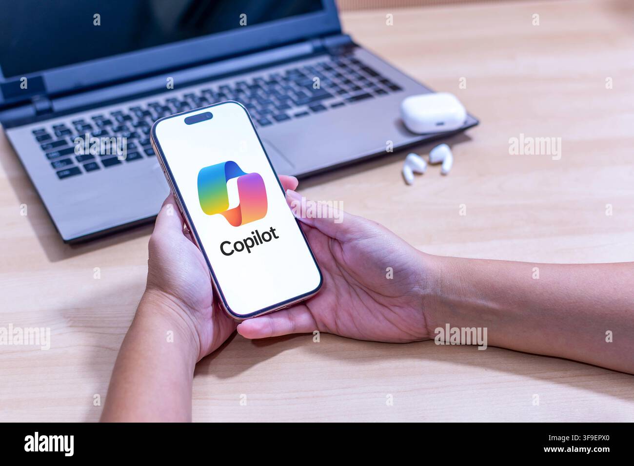 Mano che tiene un iPhone con il logo dell'app Copilot. Foto Stock