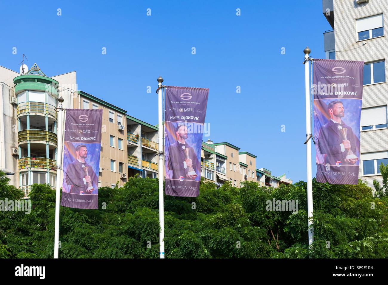 Striscioni che sventolano orgogliosamente su Belgrado, Serbia, raffiguranti la leggenda del tennis serbo Novak Djokovic che tiene il Globe Sports Award del 2025 Foto Stock