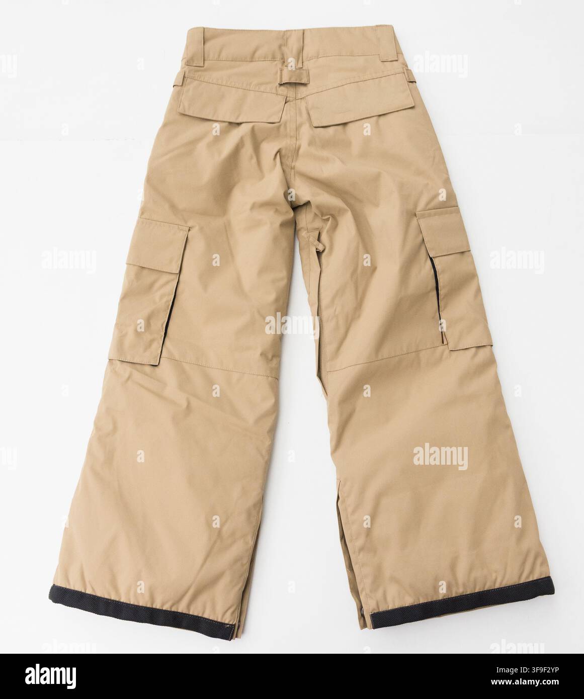L'immagine mostra pantaloni cargo marrone distesi su uno sfondo bianco Foto Stock