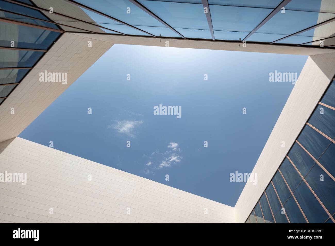 Architettura moderna minimale che incornicia un cielo blu chiaro con pareti geometriche e una facciata in vetro Foto Stock