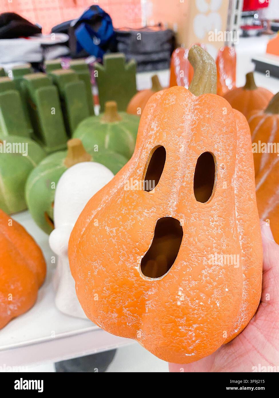 Una mano che tiene una decorazione a forma di zucca fantasma in ceramica arancione per Halloween – 8 agosto 2026, Portland Oregon, USA Foto Stock