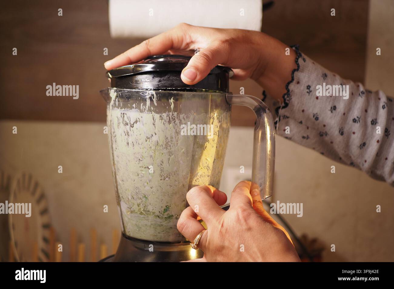 Mescolare gli ingredienti in cucina durante le ore serali Foto Stock