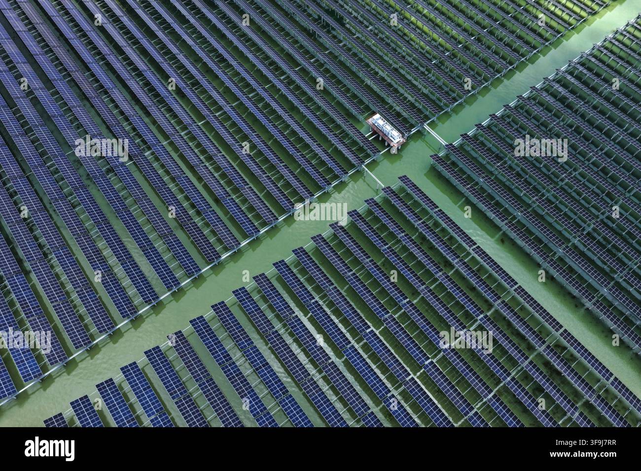 Vista aerea del parco solare di Sirajganj da 68 MW con file di pannelli solari galleggianti disposti in motivi geometrici sulla superficie dell'acqua di Sirajganj, Rajshahi D Foto Stock