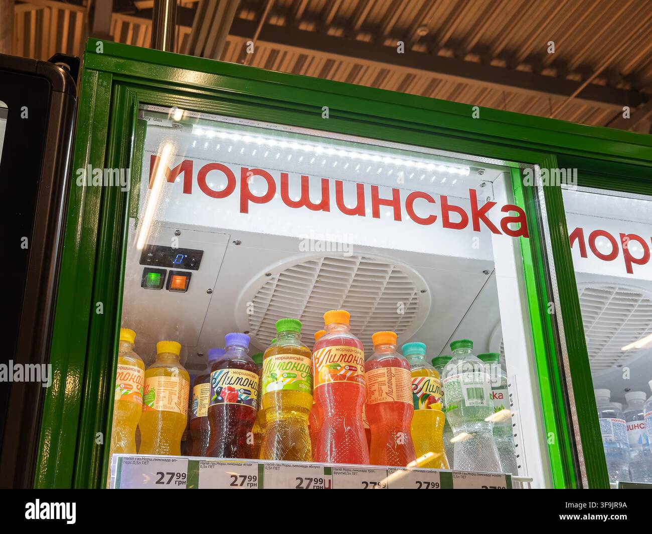 Kyiv, Ucraina – 14 marzo 2026: Il gabinetto delle bevande Morshynska espone varie bibite gassate aromatizzate dietro porte di vetro, evidenziando un investimento commerciale Foto Stock