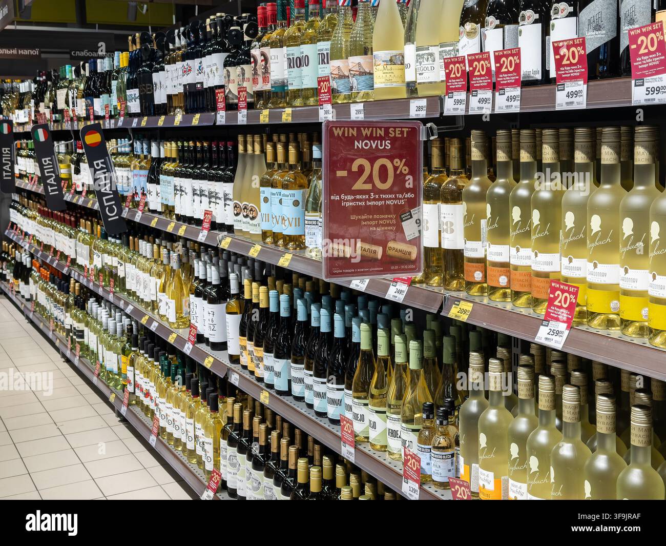 Kyiv, Ucraina - 14 marzo 2026: Diverse bottiglie di vino bianco esposte sugli scaffali di un negozio di alimentari con cartellini di riduzione del prezzo che evidenziano offerte stagionali Foto Stock