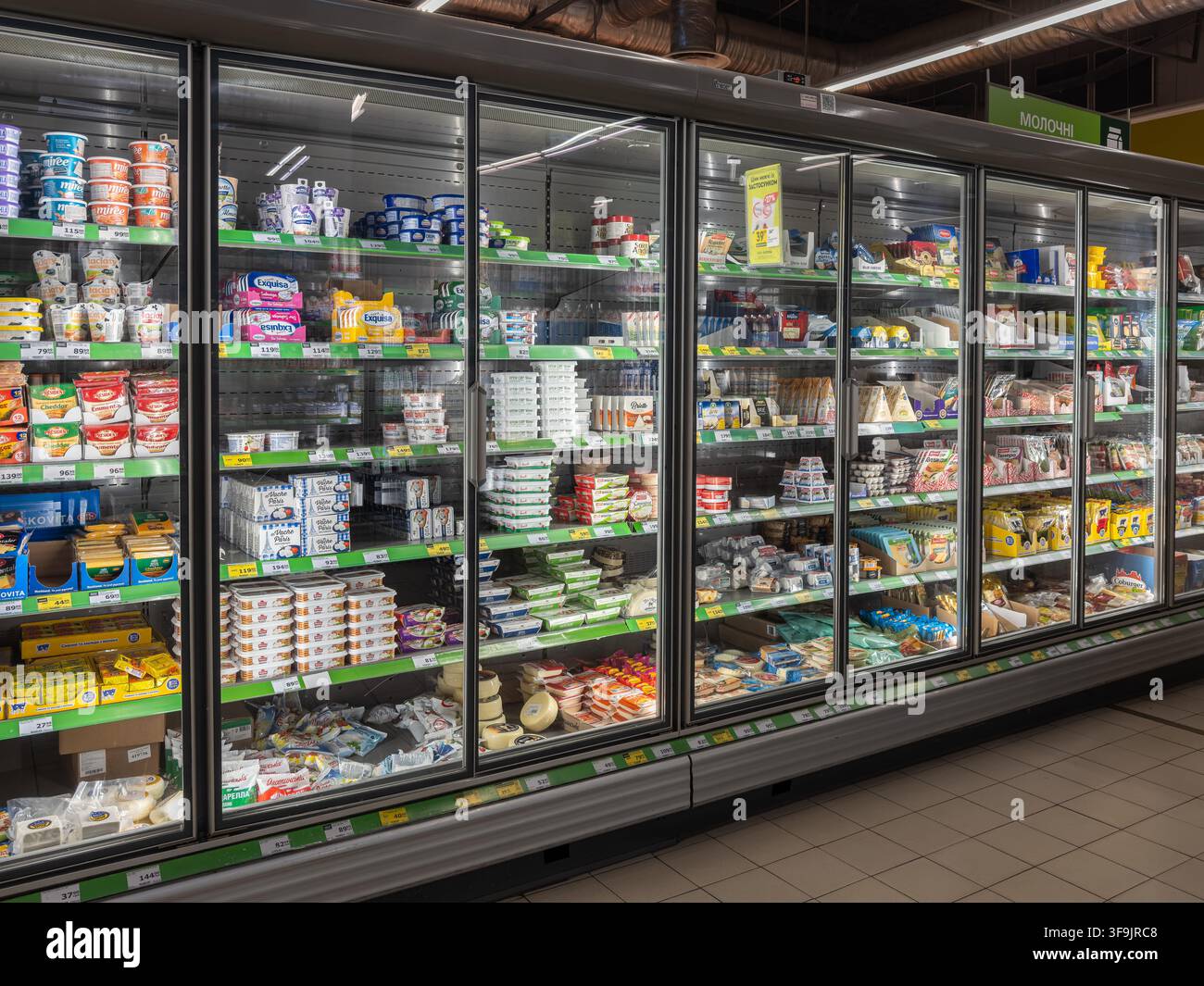 Kiev, Ucraina - 14 marzo 2026: File di formaggio fresco e yogurt sono riposti all'interno di espositori refrigerati per aiutare gli acquirenti a trovare le essenze di spesa Foto Stock