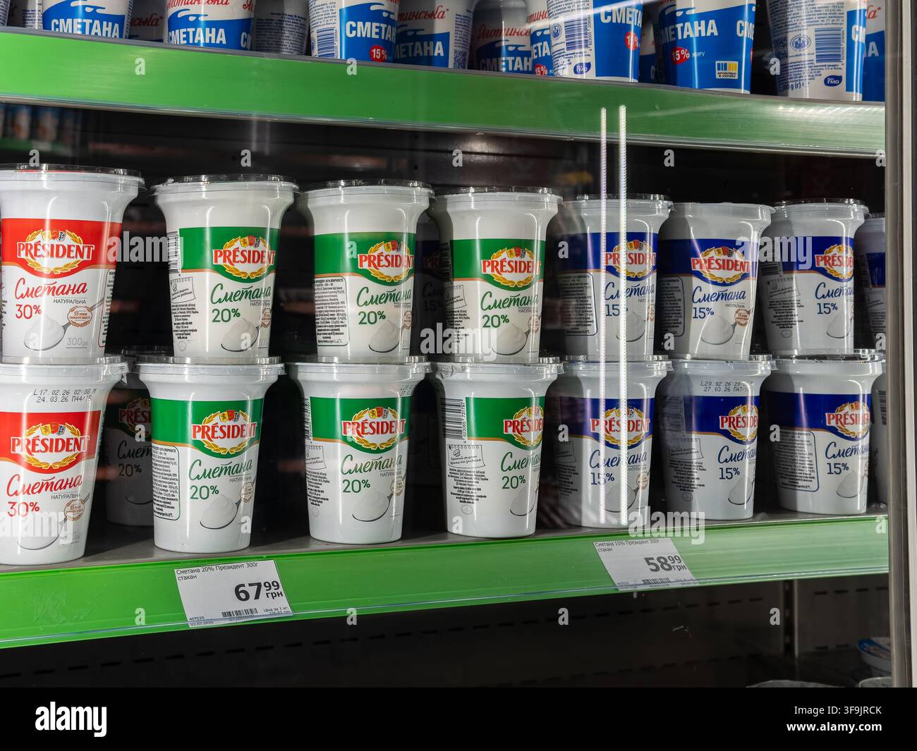 Kyiv, Ucraina - 14 marzo 2026: Contenitori President di panna acida sono disposti su scaffali all'interno di un'unità refrigerata, rappresentando una scelta comune Foto Stock