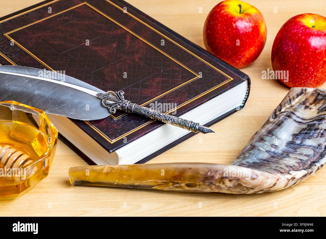 Simboli di Rosh Hashanah tra cui un libro della Torah, una penna d'oca, miele, mele e uno shofar Foto Stock