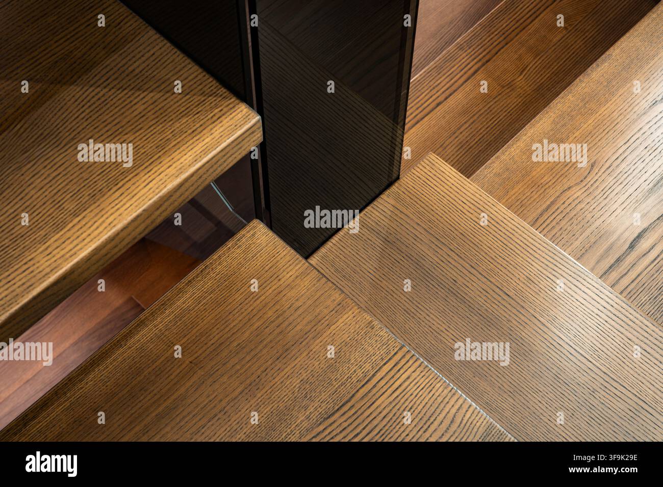 Prima avvicinata astratta di gradini di scala in legno con ricca trama di venature e angoli geometrici, dettaglio di architettura interna Foto Stock