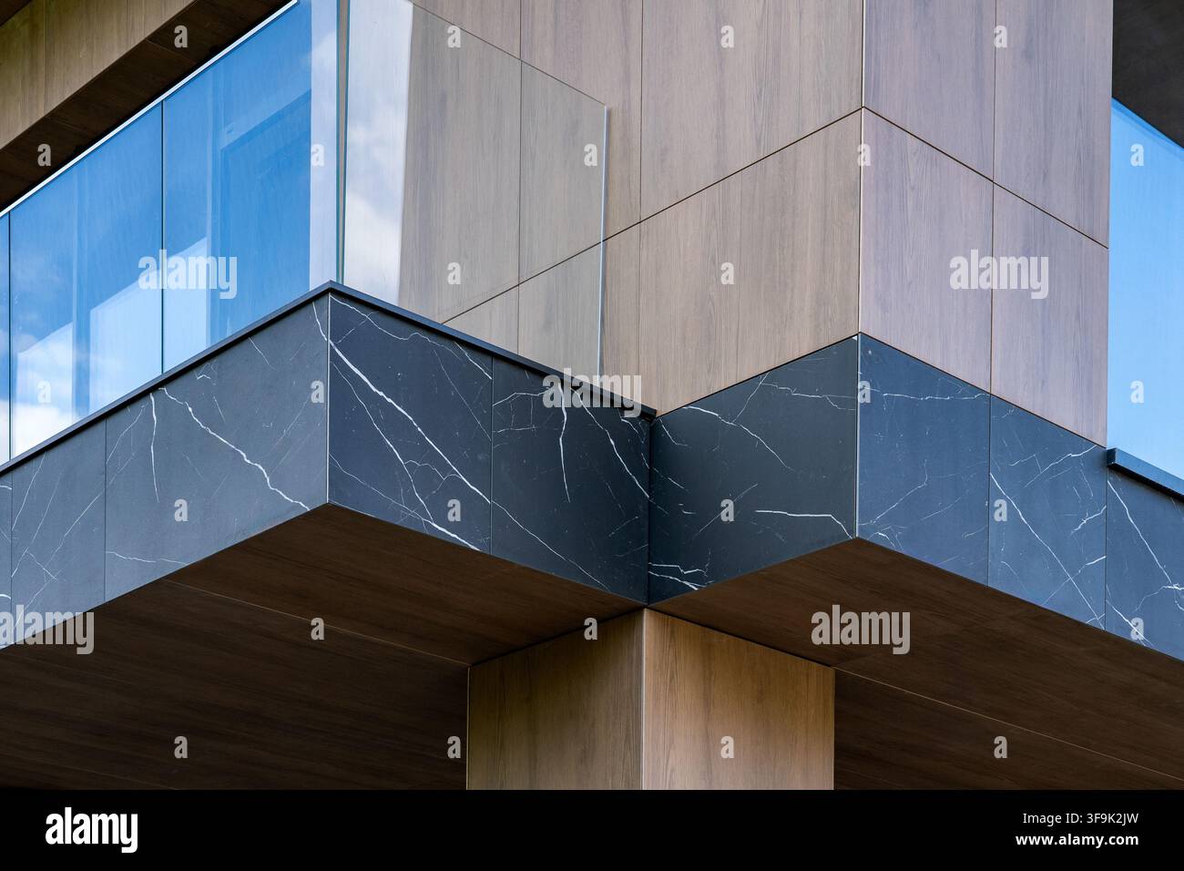 Facciata geometrica astratta di edificio con materiali in marmo, legno e vetro, primo piano di architettura moderna Foto Stock