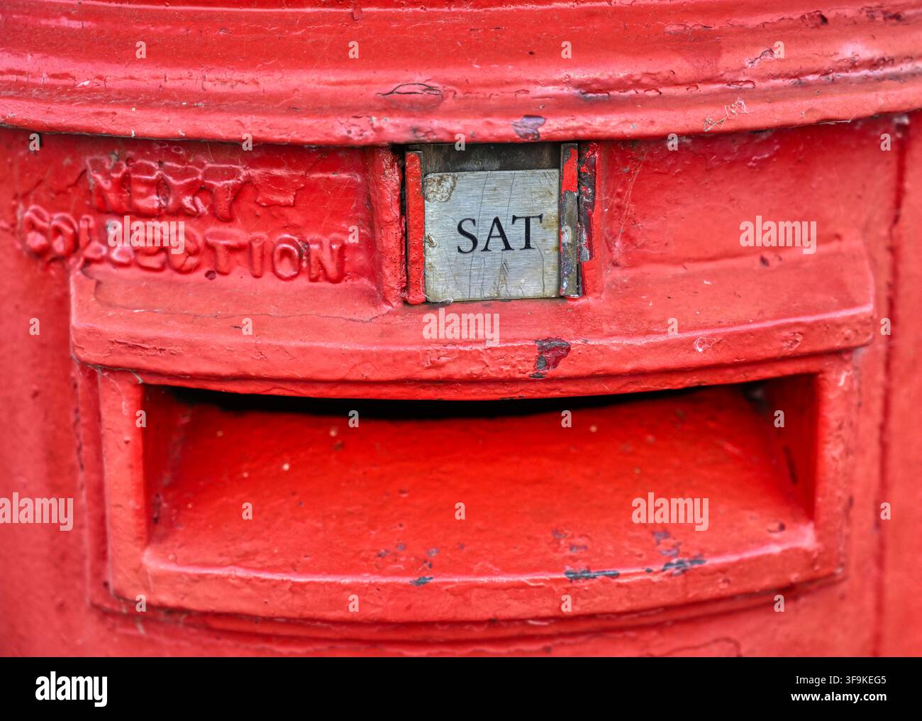 Dettaglio di una cassetta delle poste tradizionale rossa britannica rurale che dice che la prossima raccolta è prevista per sabato Foto Stock