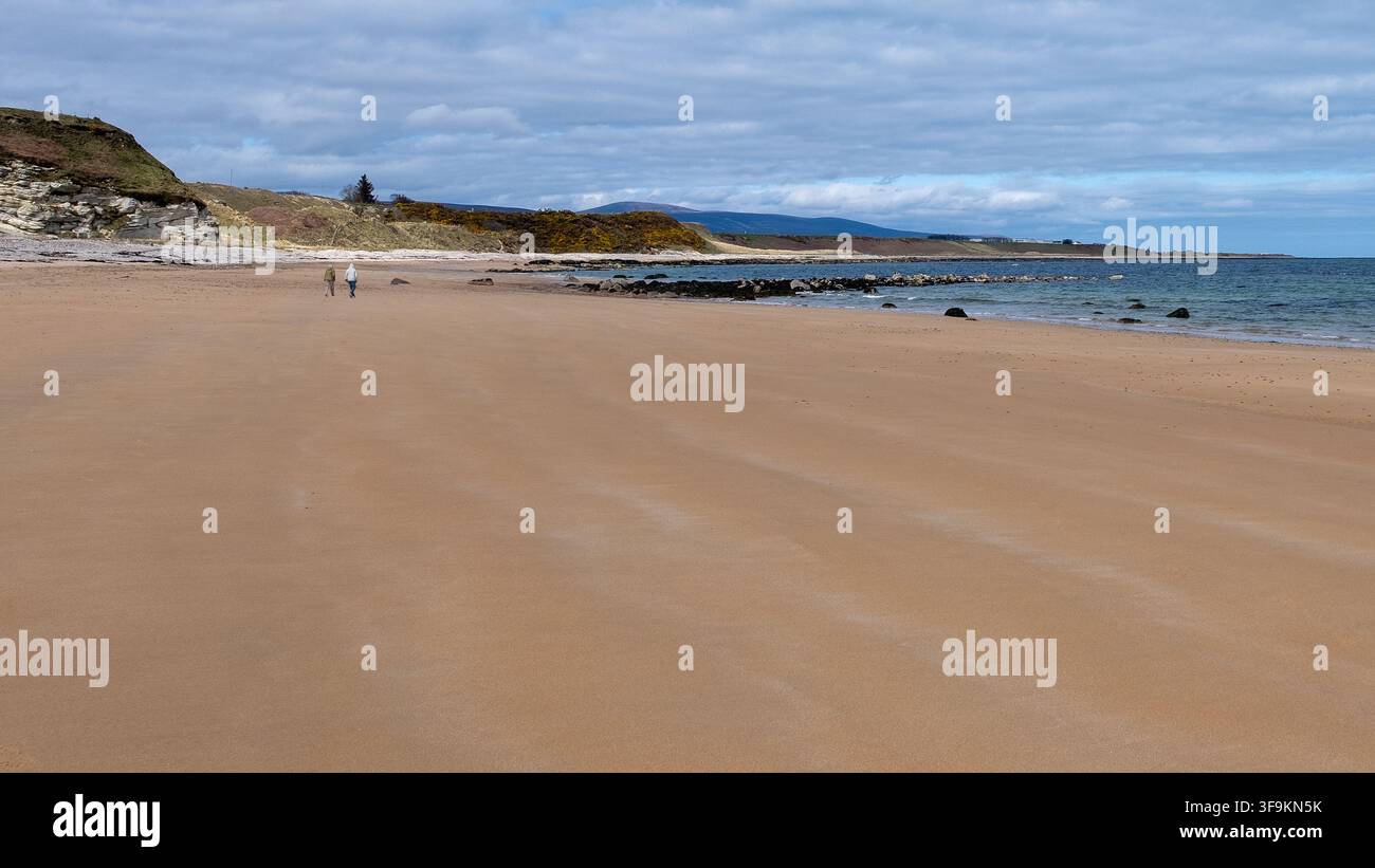 Coppia che cammina sulla spiaggia di The Coves vicino a Brora Foto Stock