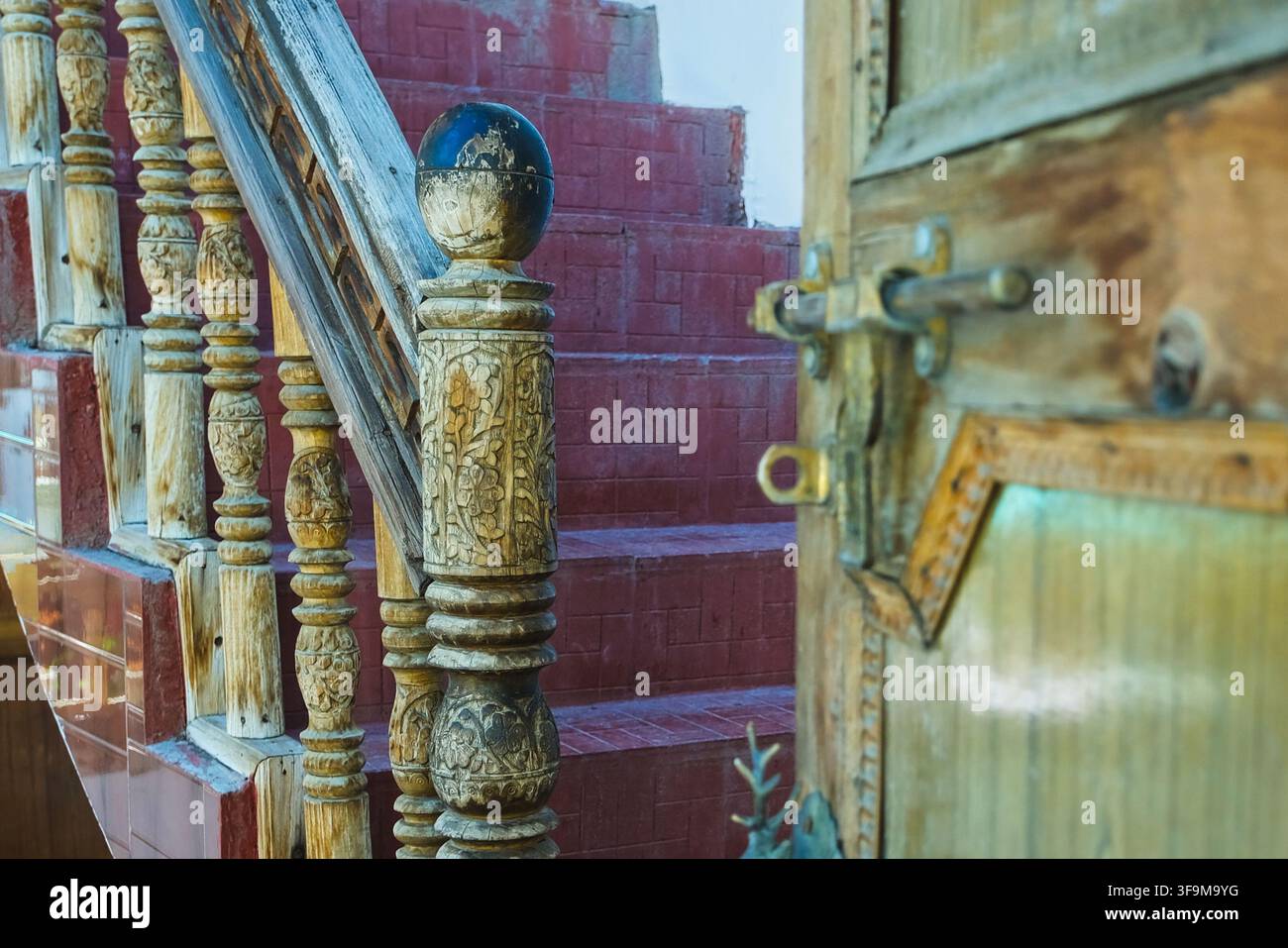 Scalinata in legno intagliato tradizionale e dettaglio architettonico tibetano nell'Himalaya. Foto Stock