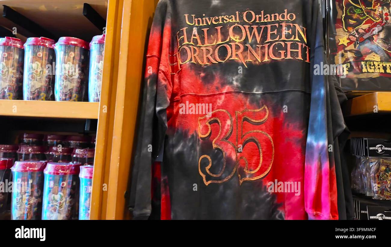 ORLANDO, FL, USA - 15 AGOSTO 2026: Una maglietta a maniche lunghe tie-dye con grafica rossa e nera con la scritta 'Halloween Horror Nights' e il numero 35, esposta Foto Stock