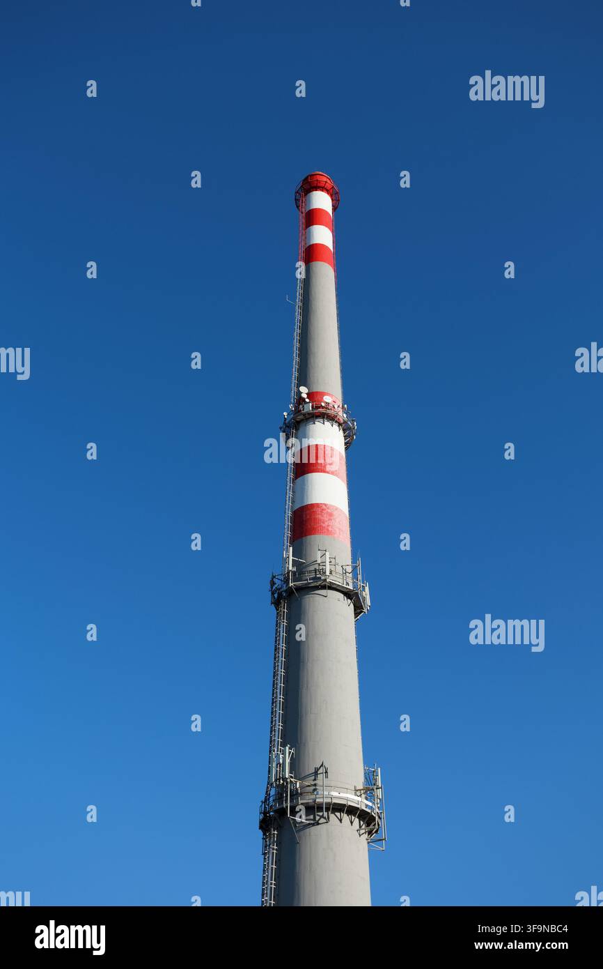 Caminetto e camino contro un cielo blu chiaro. Architettura industriale ed edificio senza fumo, che simboleggia zero emissioni, inquinamento ridotto, un Foto Stock