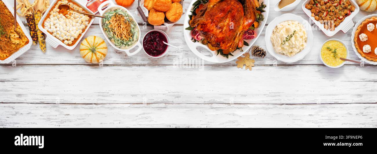 Cena tradizionale di tacchino del Ringraziamento. Vista dall'alto bordo superiore su uno sfondo di banner in legno bianco rustico. Tacchino, purè di patate, ripieno, zucca Foto Stock