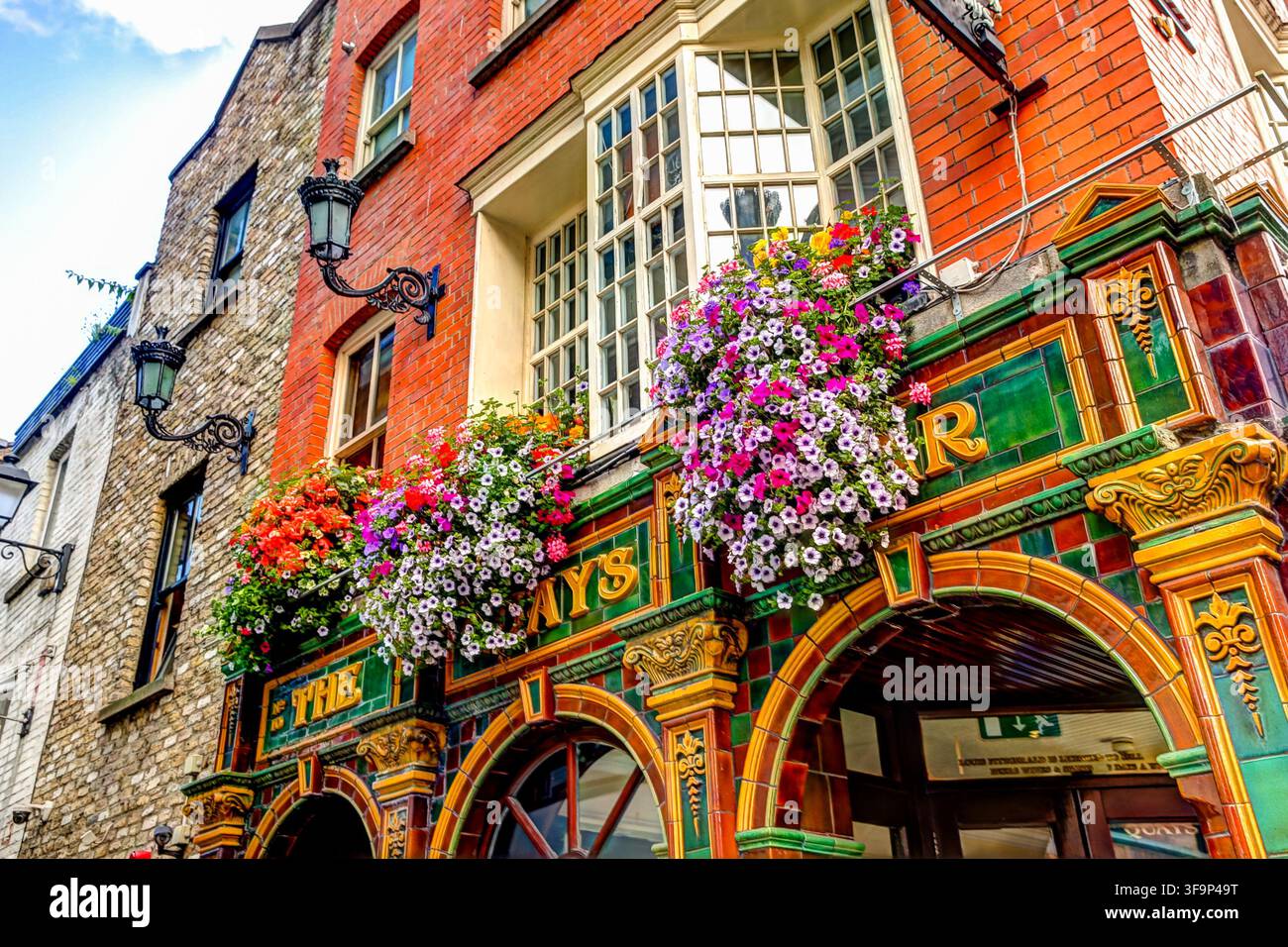 Il Quays Irish Restaurant a Temple Bar presenta una facciata tradizionale ornata ricoperta da colorati cesti di fiori sospesi. Foto Stock