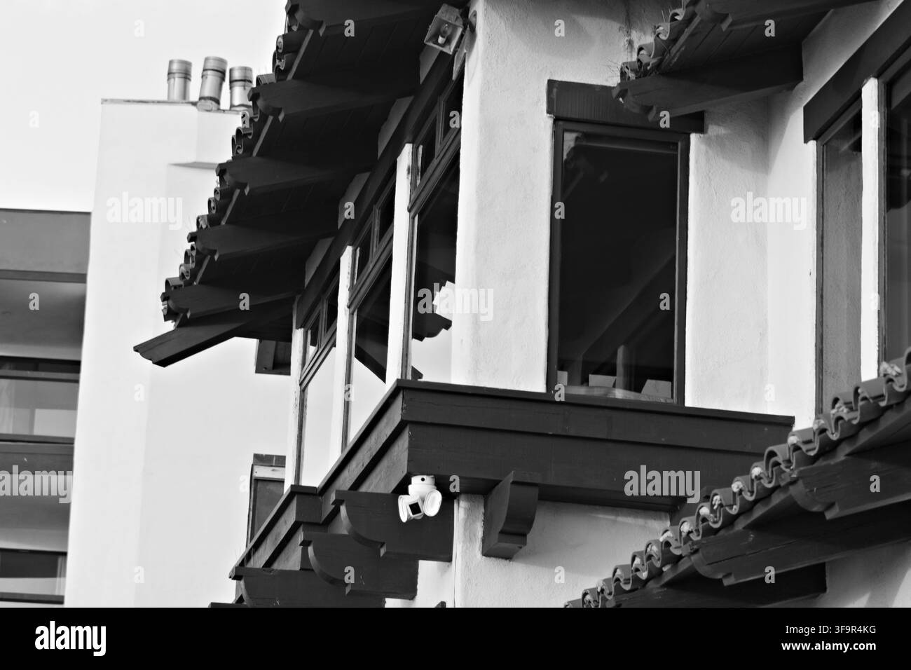 Prima vista di un edificio tradizionale con balconi in legno e tegole in terracotta. Le pareti in stucco bianco contrastano con le travi e i timpani in legno scuro. Costruzione moderna Foto Stock