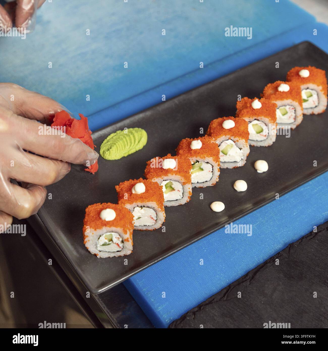 Chef che mette lo zenzero al tavolo del sushi, California Unagi Sushi Roll Foto Stock