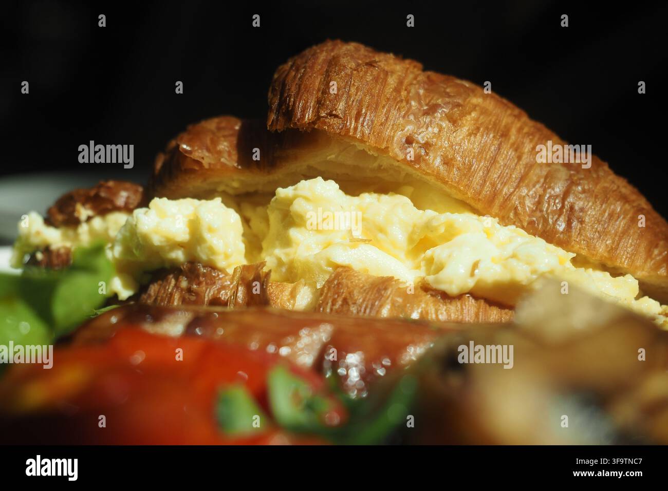 Colazione servita su un croissant con uova e verdure Foto Stock