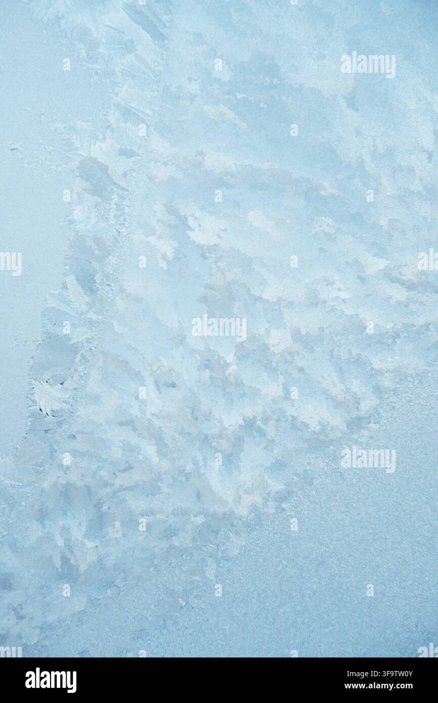 Bellissimi motivi ghiacciati su una finestra blu Foto Stock