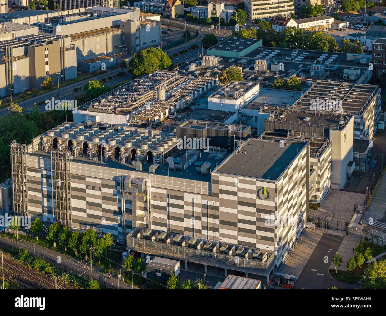 Francoforte sul Meno, Germania - 11 agosto 2026: Vista aerea del centro dati Global Switch con facciata geometrica, unità di raffreddamento sul tetto e circostante Foto Stock