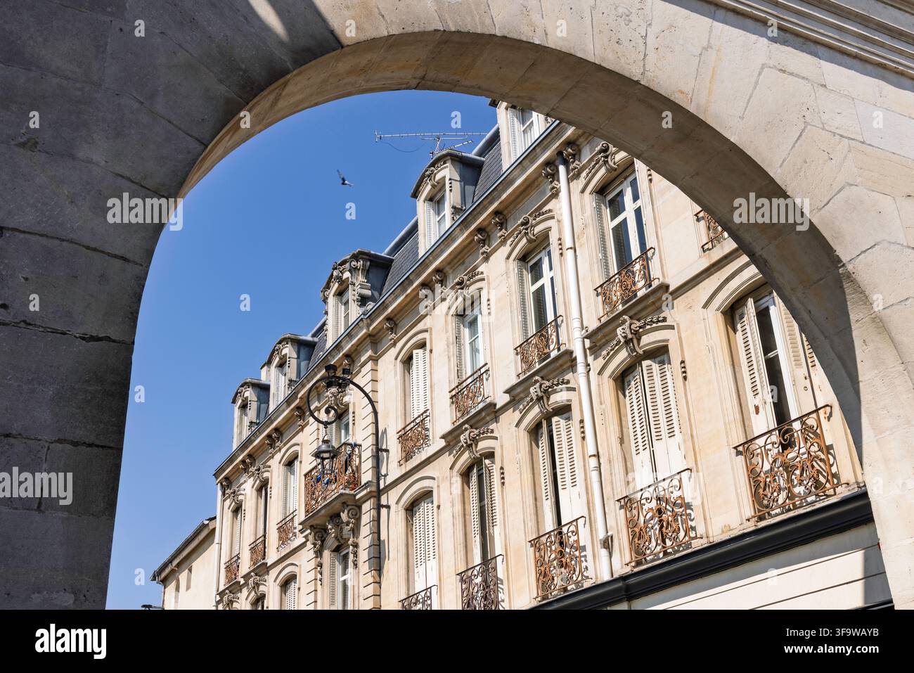 Nancy, Francia. Architettura classica francese incorniciata da un arco in pietra storico sotto un cielo blu limpido. Foto Stock