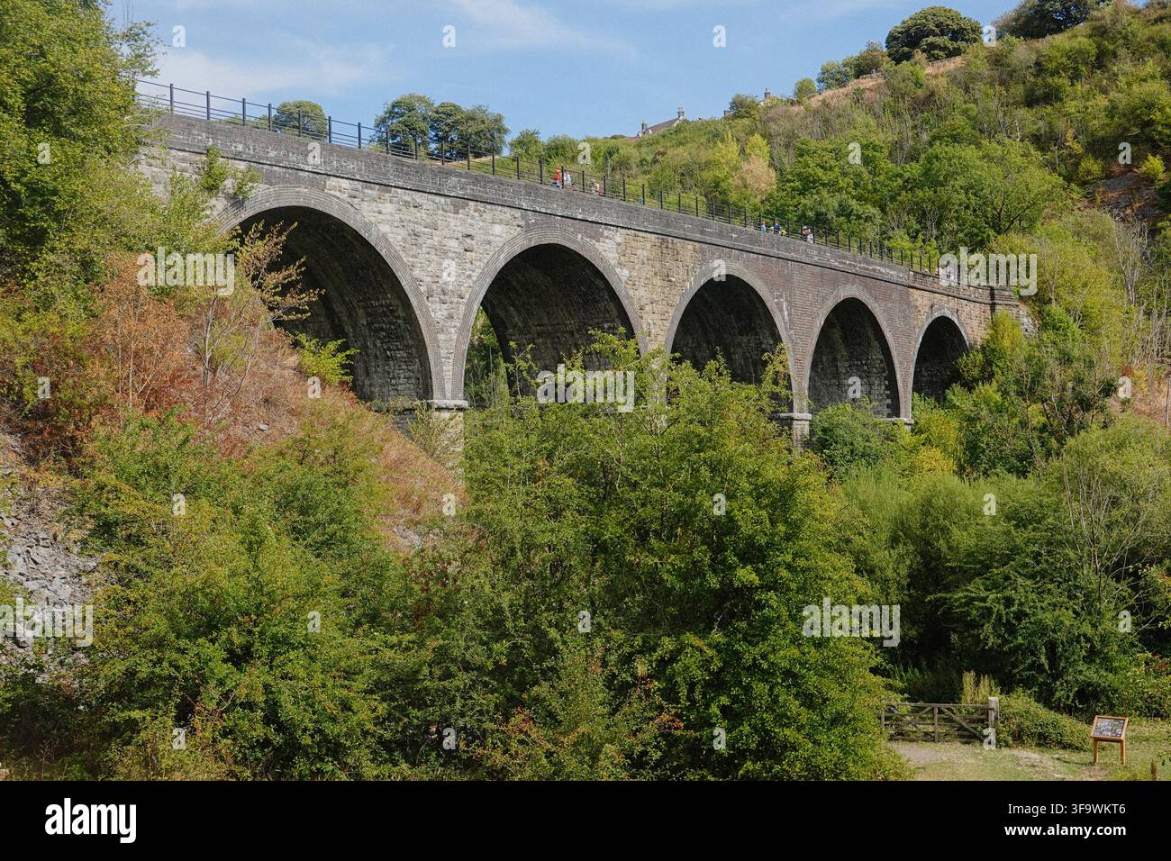 Persone che camminano e pedalano attraverso il viadotto storico di Headstone sul Monsal Trail a Monsal Dale, nel Peak District National Park, Derbyshire, Regno Unito. Foto Stock