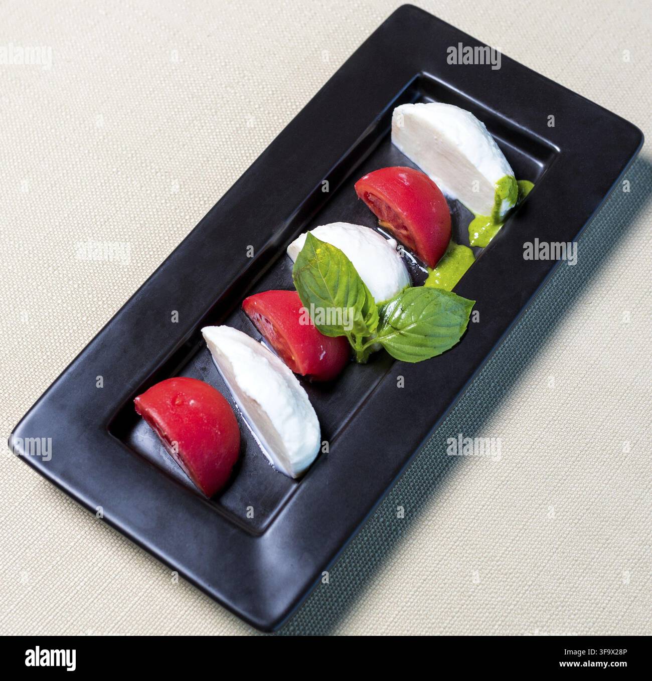 Belle palle di gelato con pomodoro sul piatto nero Foto Stock
