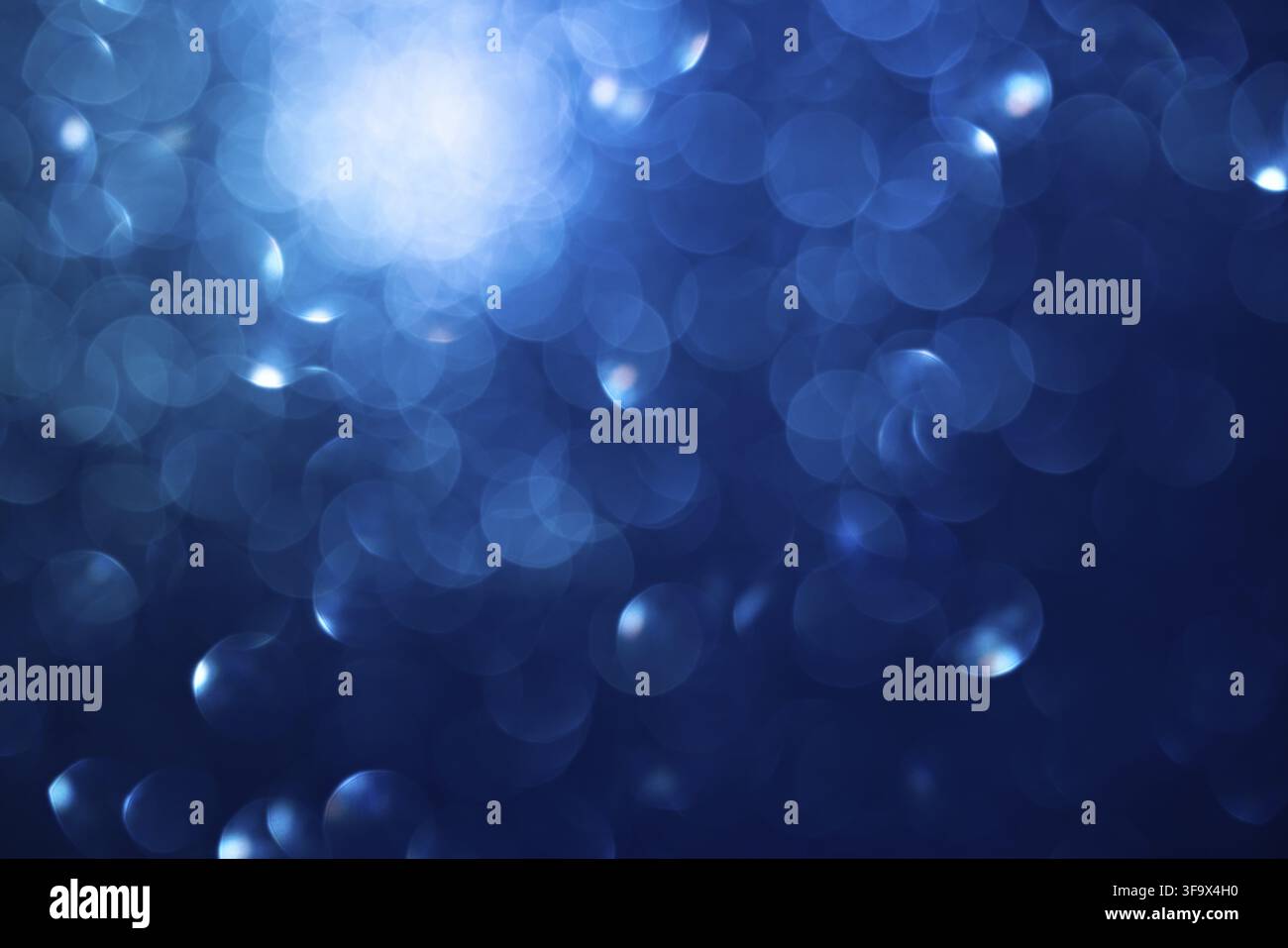 Sfondo bokeh blu astratto con luci soffuse e cerchi scintillanti Foto Stock