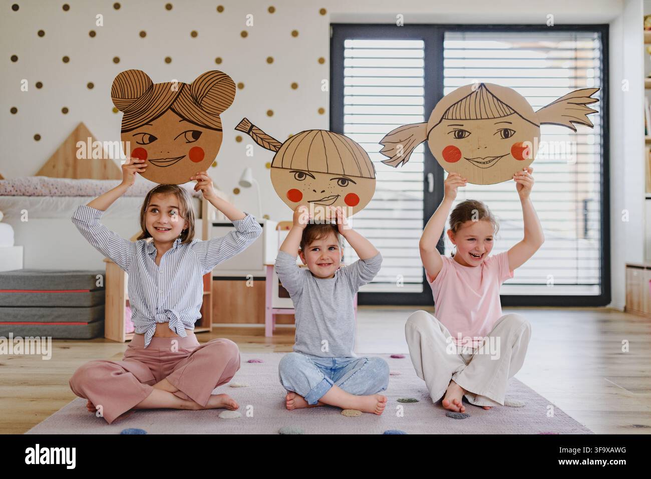 Bambini che esplorano emozioni ed espressioni facciali attraverso il gioco creativo. Foto Stock