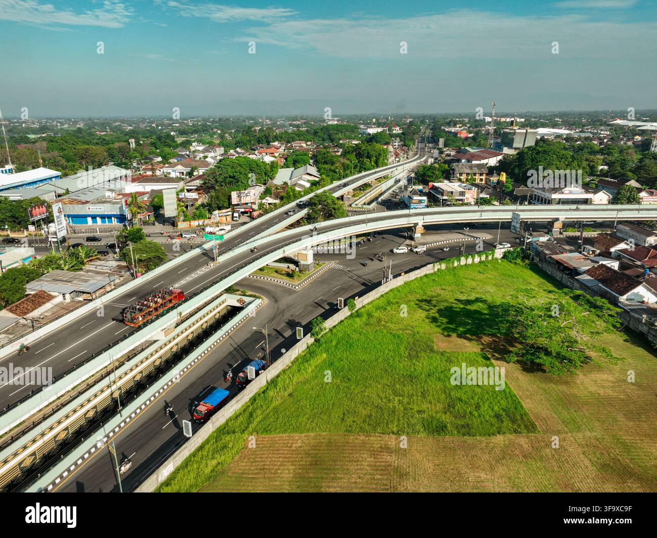 Sleman, Indonesia - 24 maggio 2023: Veduta aerea del Flyover Jombor con il traffico che scorre sulla strada elevata, circondata da edifici urbani, campi verdi, Foto Stock