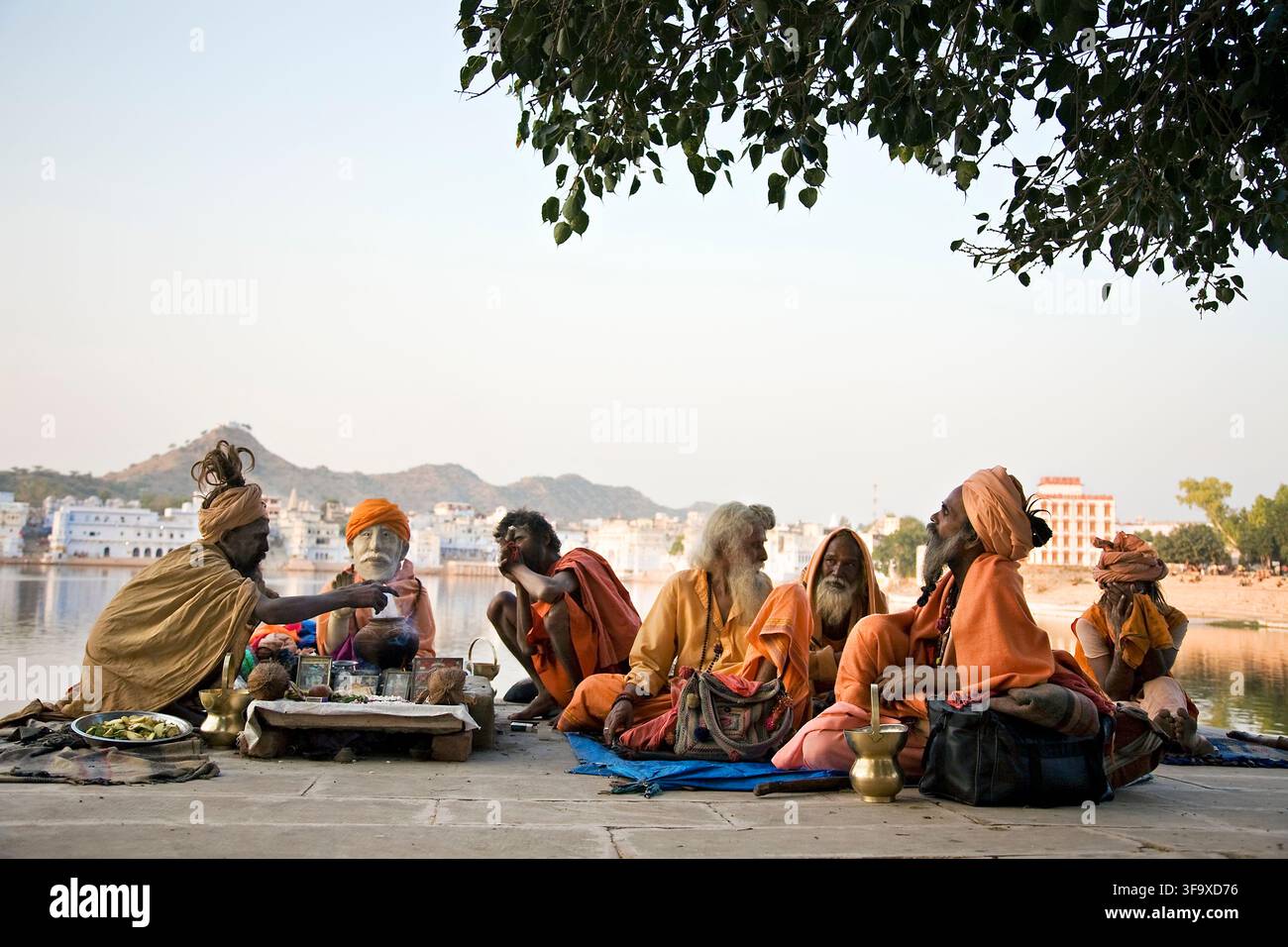 Un gruppo di Sadhu fuma seduto in un tempio all'aperto Foto Stock