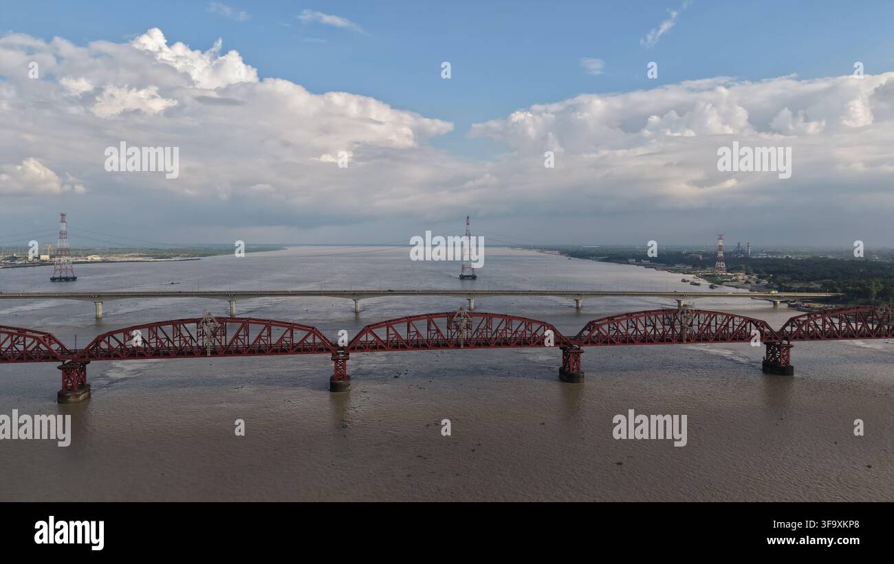 Storico ponte ferroviario a traliccio rosso che attraversa un ampio fiume Foto Stock