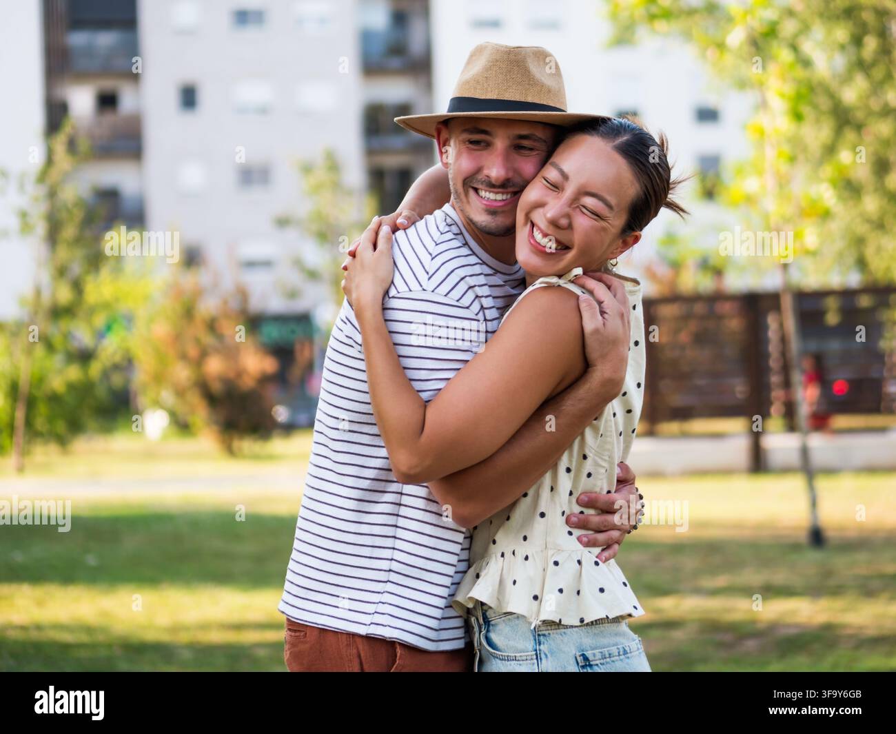 Coppia affettuosa che si tiene per mano e sorride mentre trascorre del tempo di qualità insieme all'aperto. Foto Stock