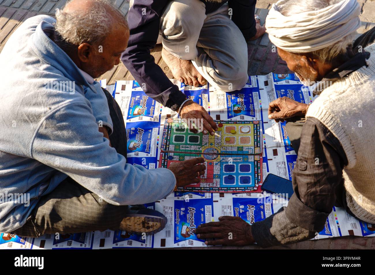 India. Uttarakhand. Haridwar. Uomini giocano a Ludo in una strada della città // India. Uttarakhand. Haridwar. Un gruppo di uomini sta giocando a Ludo su una s Foto Stock