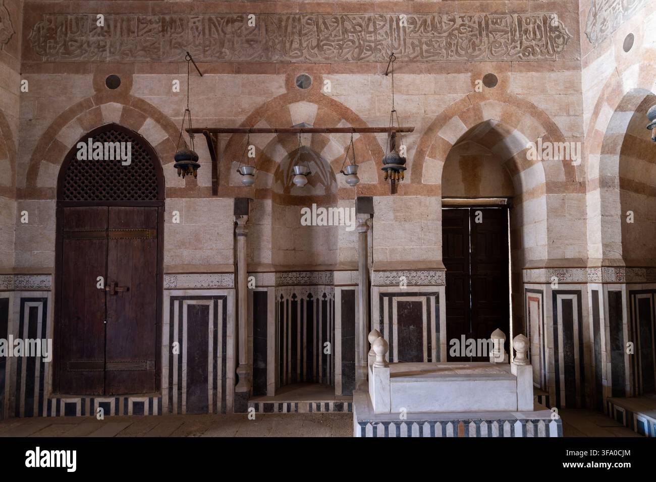 Vista dell'interno del complesso funerario di Amir Khayrbak con i suoi caratteristici archi in pietra, intarsi di marmo e il cenotafio storico a El-Darb El-Ahmar, Foto Stock