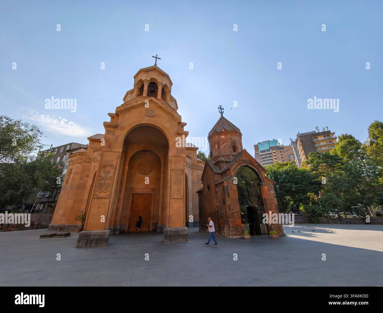 Chiesa di Sant'Anna con ingresso ad arco e cupola. Persona che cammina vicino alla struttura. Alberi ed edifici moderni visibili sullo sfondo. Cielo azzurro sopra Foto Stock