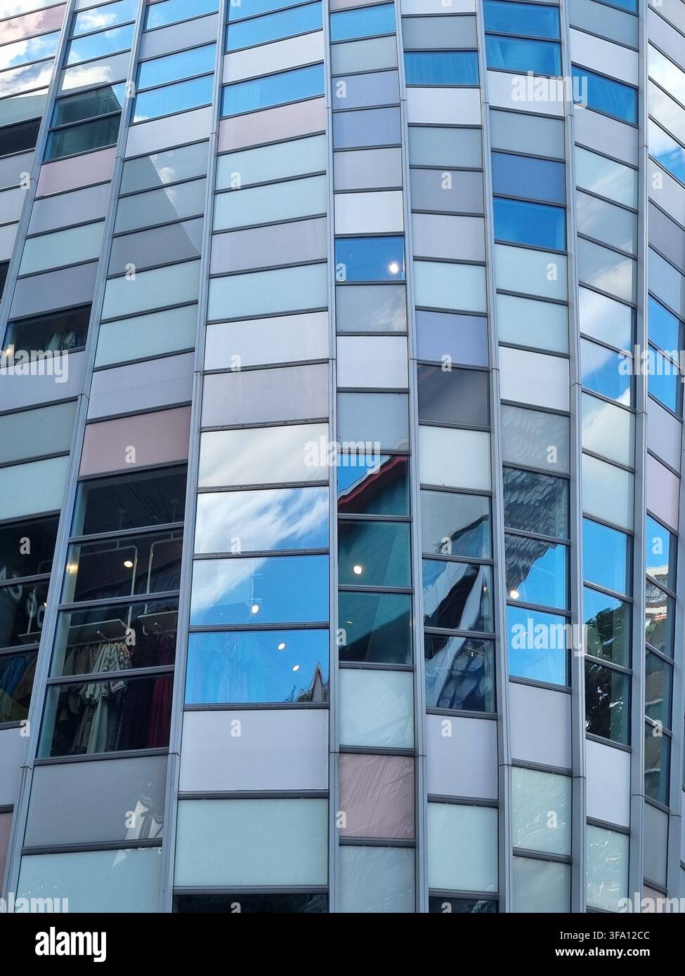 Vista astratta diagonale di una facciata in vetro di edificio moderno che riflette il cielo azzurro e le nuvole a Utrecht. Concetto di trasparenza aziendale, architettonica p - Immagine stock catturata con smartphone