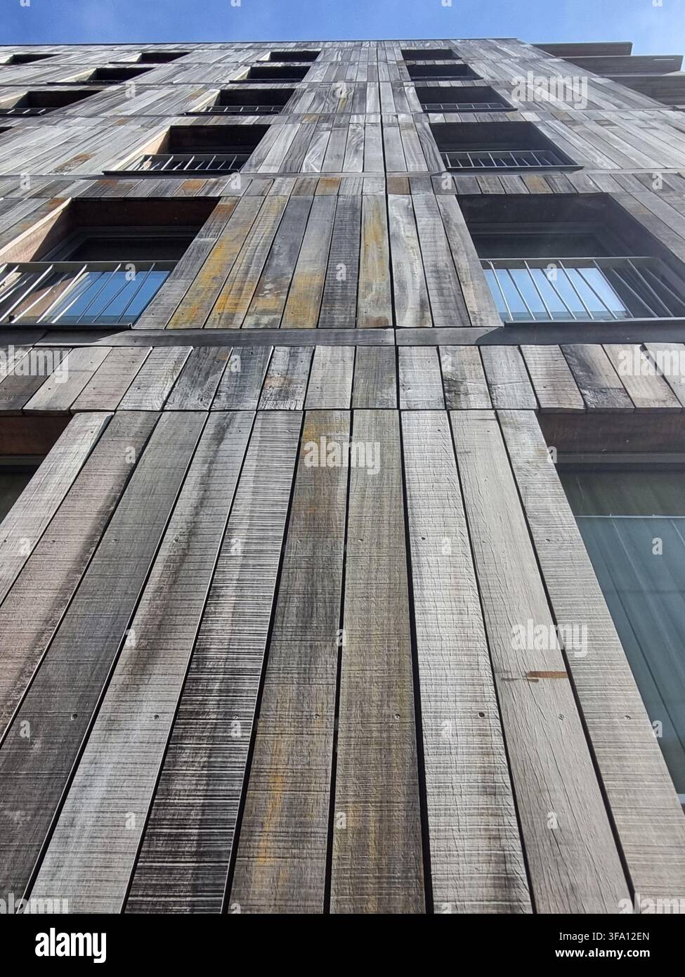 Vista drammatica a occhio di verme di un edificio moderno con facciata in legno naturale e balconi ad Amsterdam. Concetto di materiali da costruzione sostenibili, eco-compatibili - Immagine stock catturata con smartphone