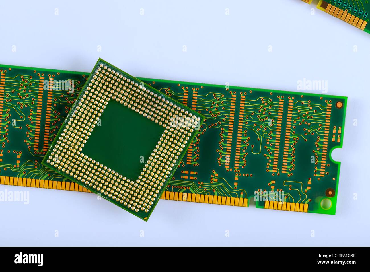 Il microprocessore è posizionato su componenti elettronici di scheda a circuito RAM verde su una superficie di lavoro. Foto Stock